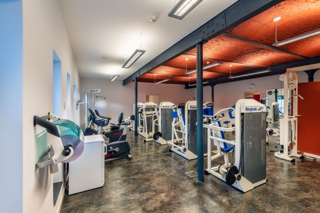 Fitnessraum mit Kraftgeräten und Ergometern